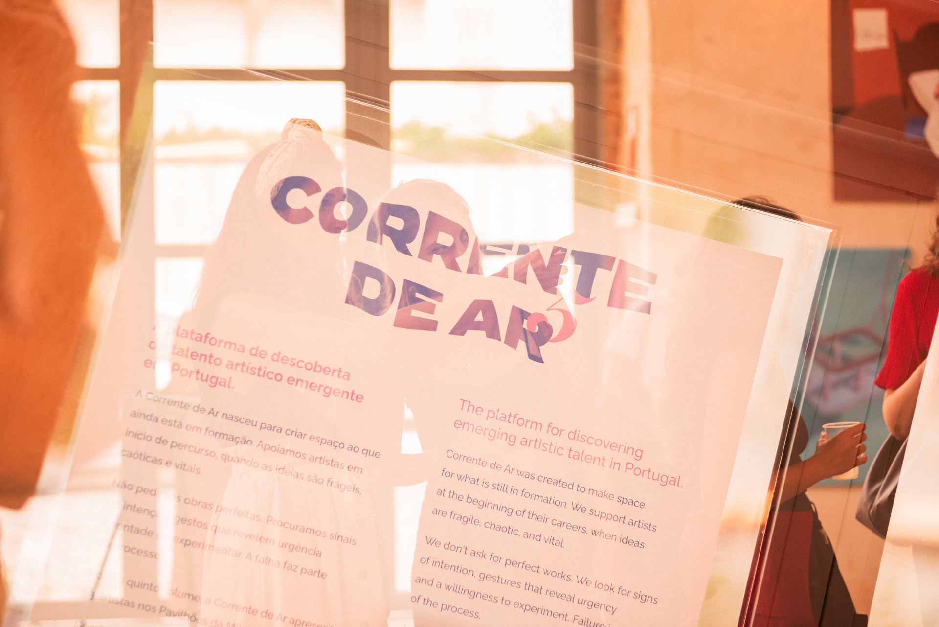 Corrente de Ar V manifesto printed on acrylic, backlit by afternoon sun