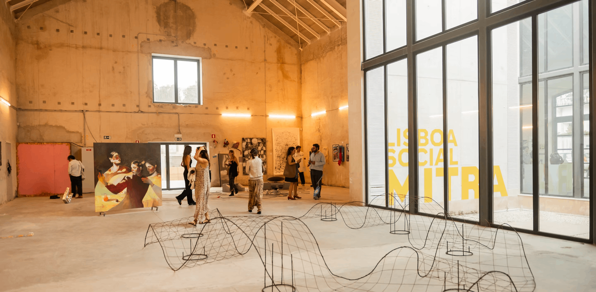 Wide view of the Mitra pavilion during Volume V, with paintings and a wire sculpture installation